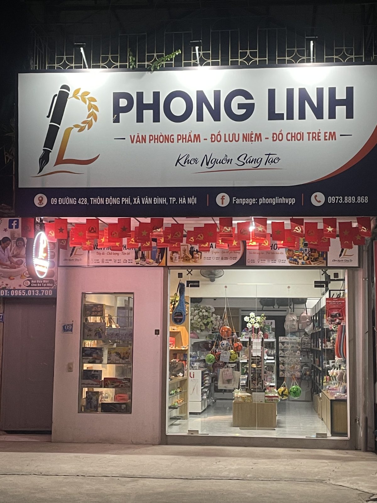 Cửa hàng Phong Linh của anh Hảo ở thôn Động Phí, xã Vân Đình lúc lên đèn, bán văn phòng phẩm, đồ lưu niệm và đồ chơi trẻ em; những hôm anh ra công trường, mẹ vợ anh trông quầy ở đây.