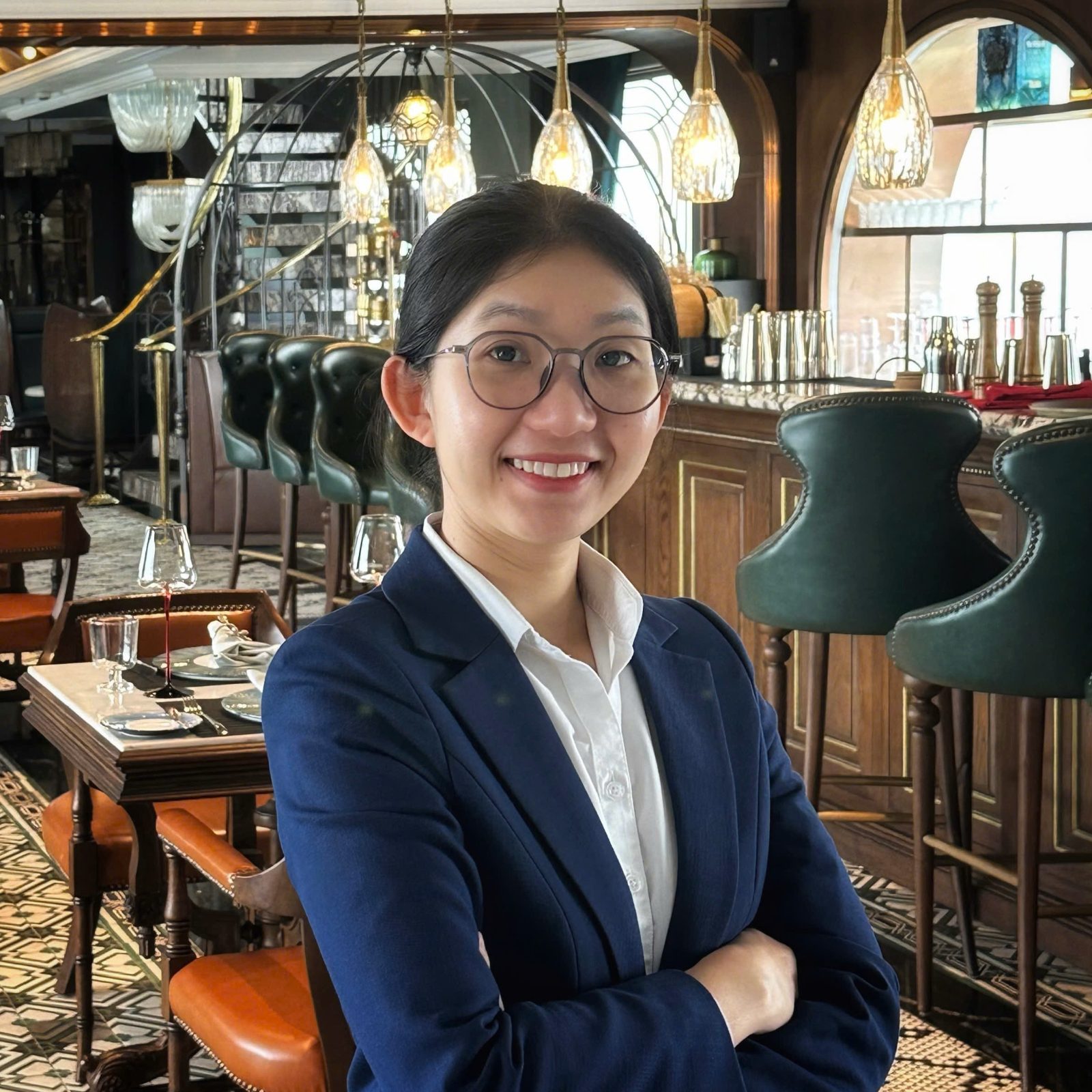 Chị Thảo trong bộ vest xanh giữa gian nhà hàng và quầy bar, nghề chị bắt đầu từ sau quầy pha chế ở Cần Thơ năm 2015.