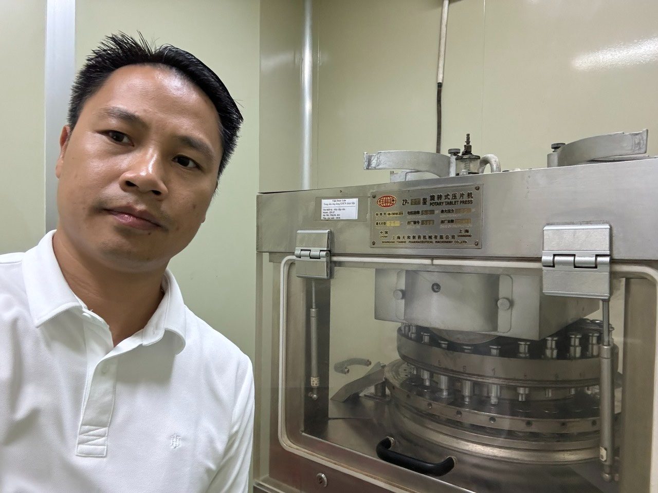 Anh Hoàn bên một chiếc máy dập viên ở cơ sở ứng dụng công nghệ dược liệu, người từng làm kỹ thuật cơ khí ở nhà máy Nhật nay đứng giữa máy móc của nghề thảo dược.
