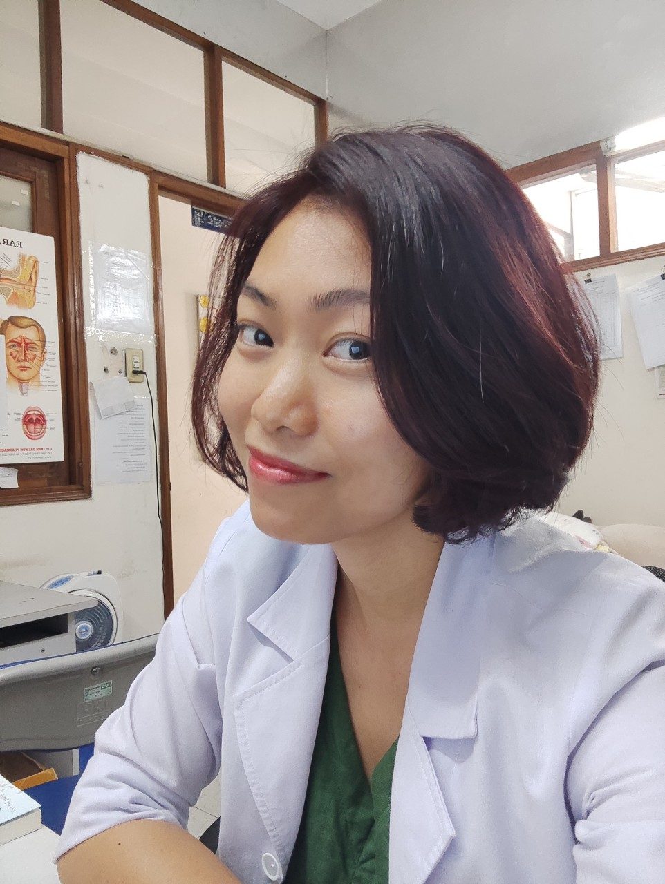 Chị Dung trong chiếc áo blouse trắng ở phòng khám, nơi chị hỏi kỹ từng người bệnh về chuyện đứng ngồi, ăn uống trước khi dặn dò.