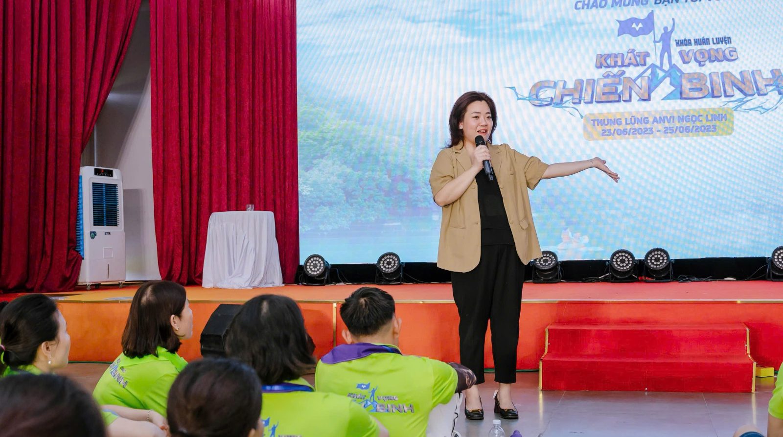 Chị Trang đứng chia sẻ trước hàng trăm người ở khóa huấn luyện Khát vọng Chiến binh tháng 6/2023, một trong những chương trình đông người chị dẫn dắt.